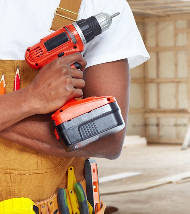 Builder handyman with construction tools. House renovation background.